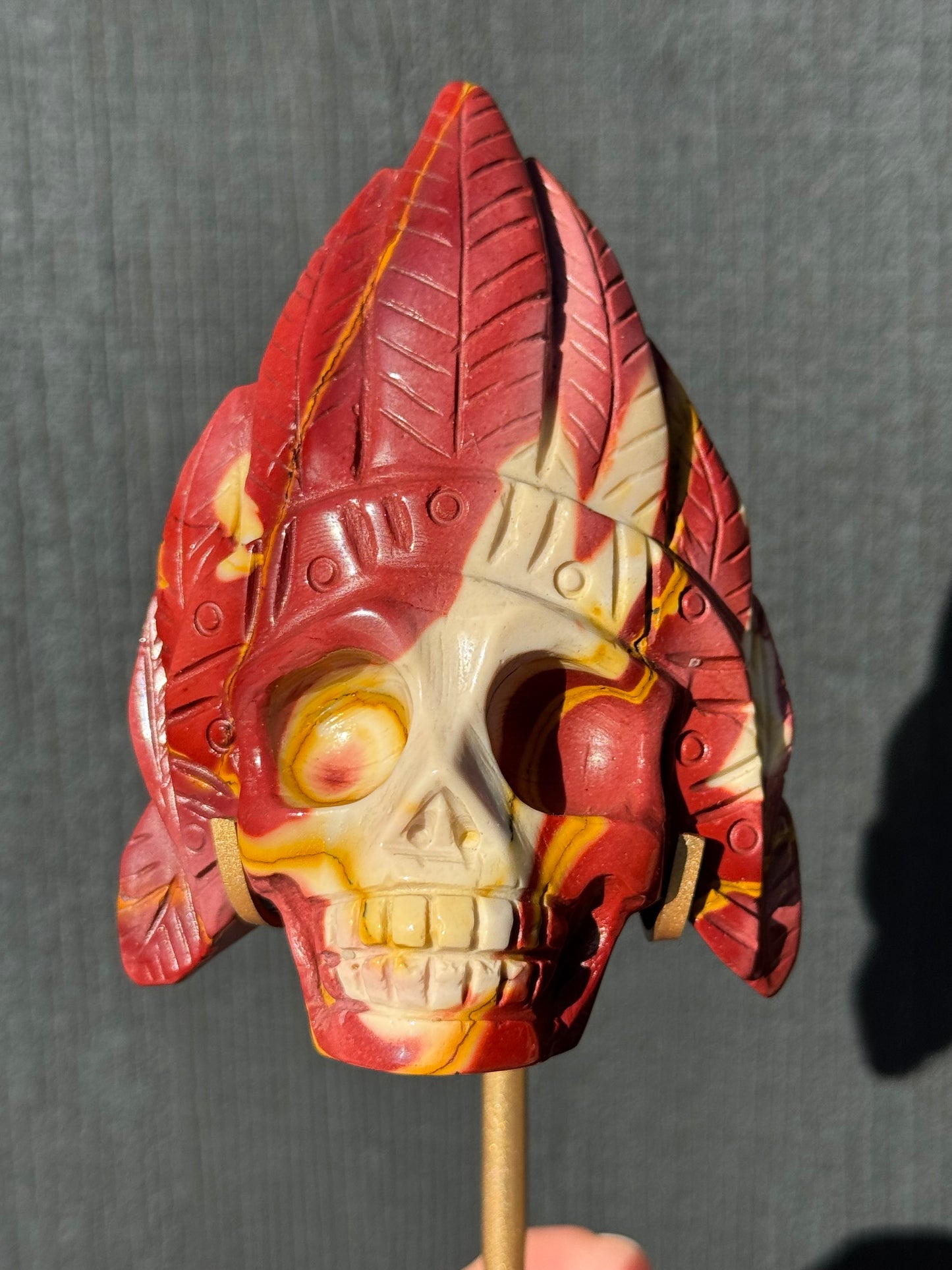 Mookaite Jasper carved Skull with Feathers on a stand