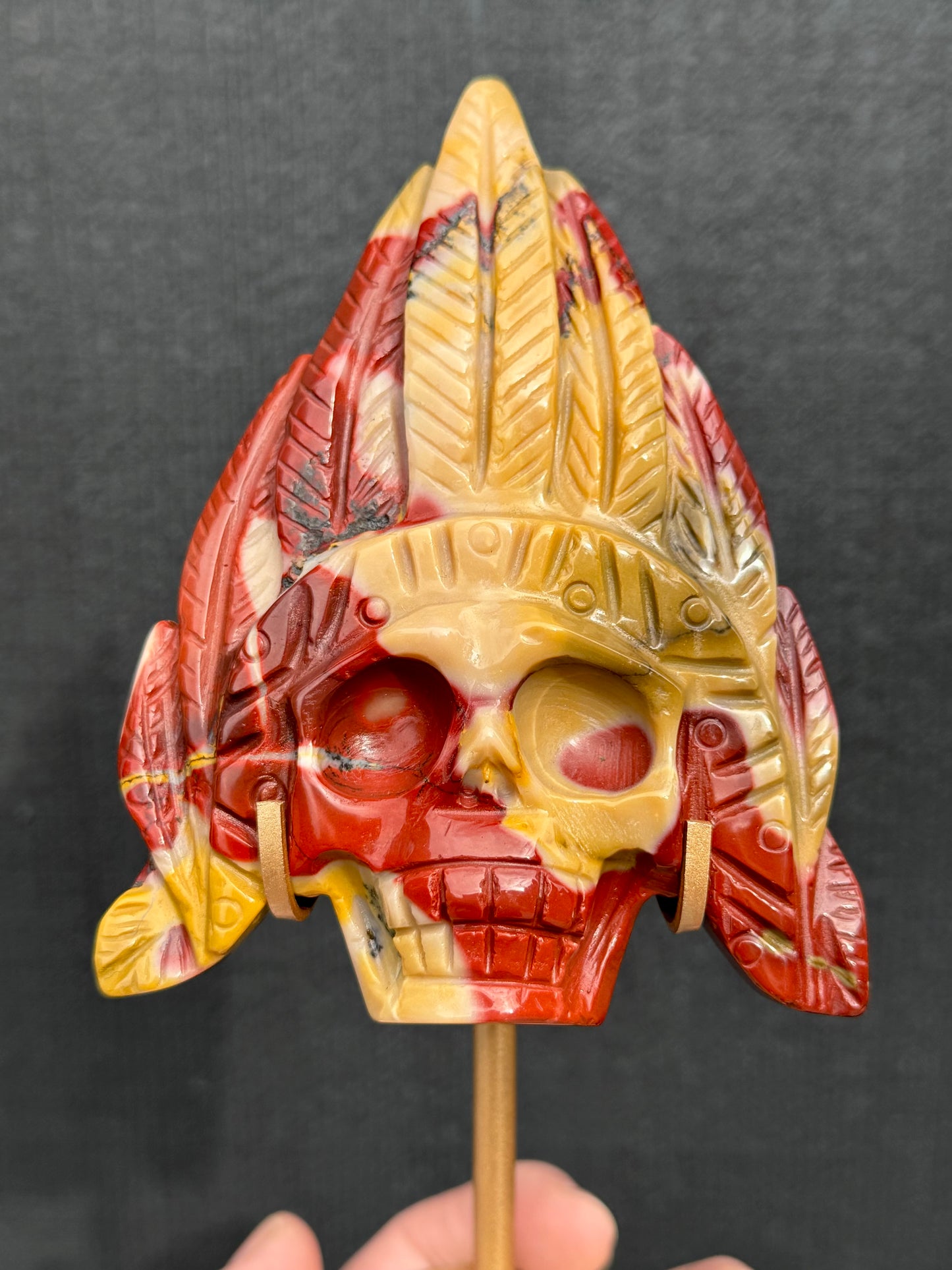 Mookaite Jasper carved Skull with Feathers on a stand