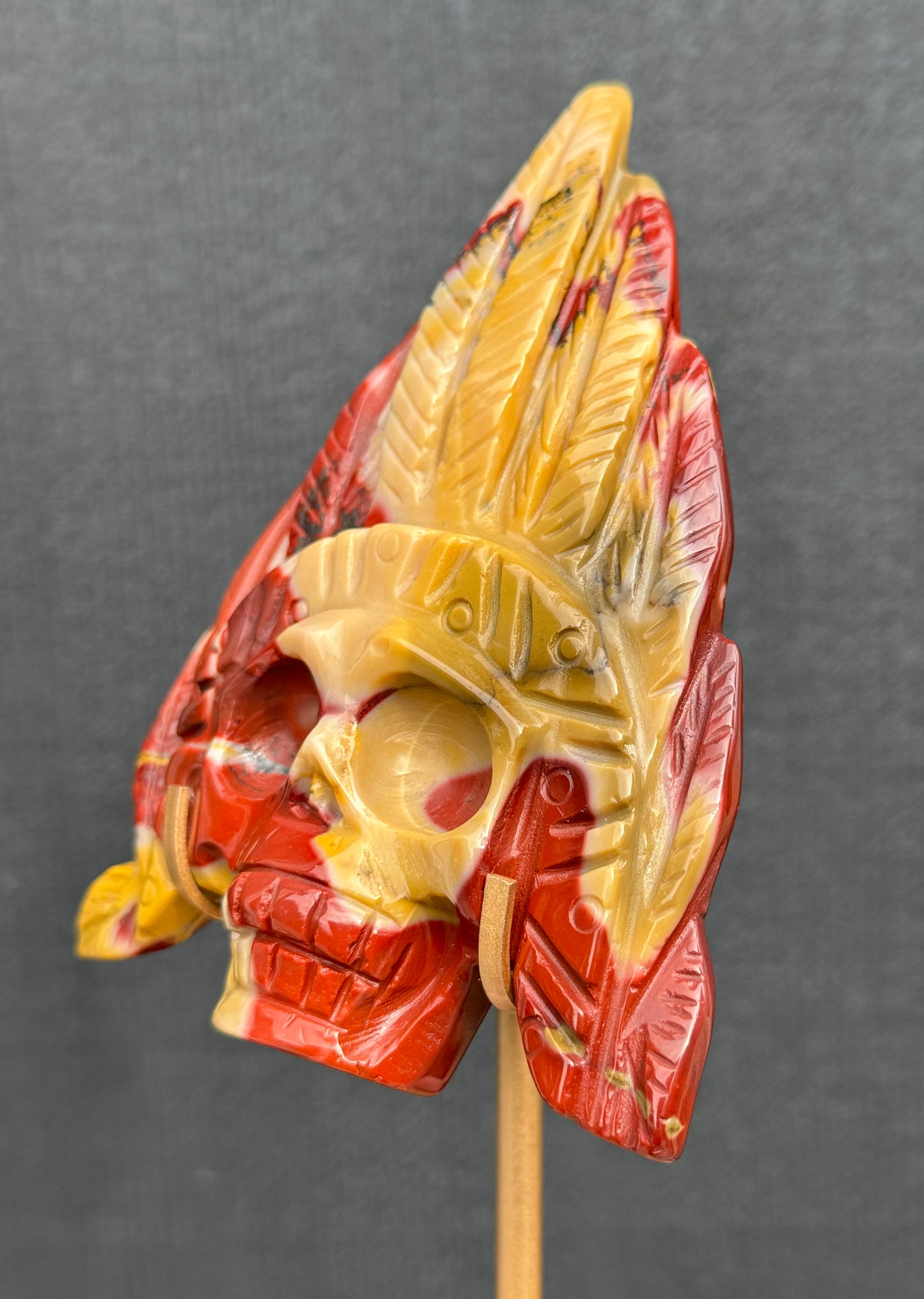 Mookaite Jasper carved Skull with Feathers on a stand