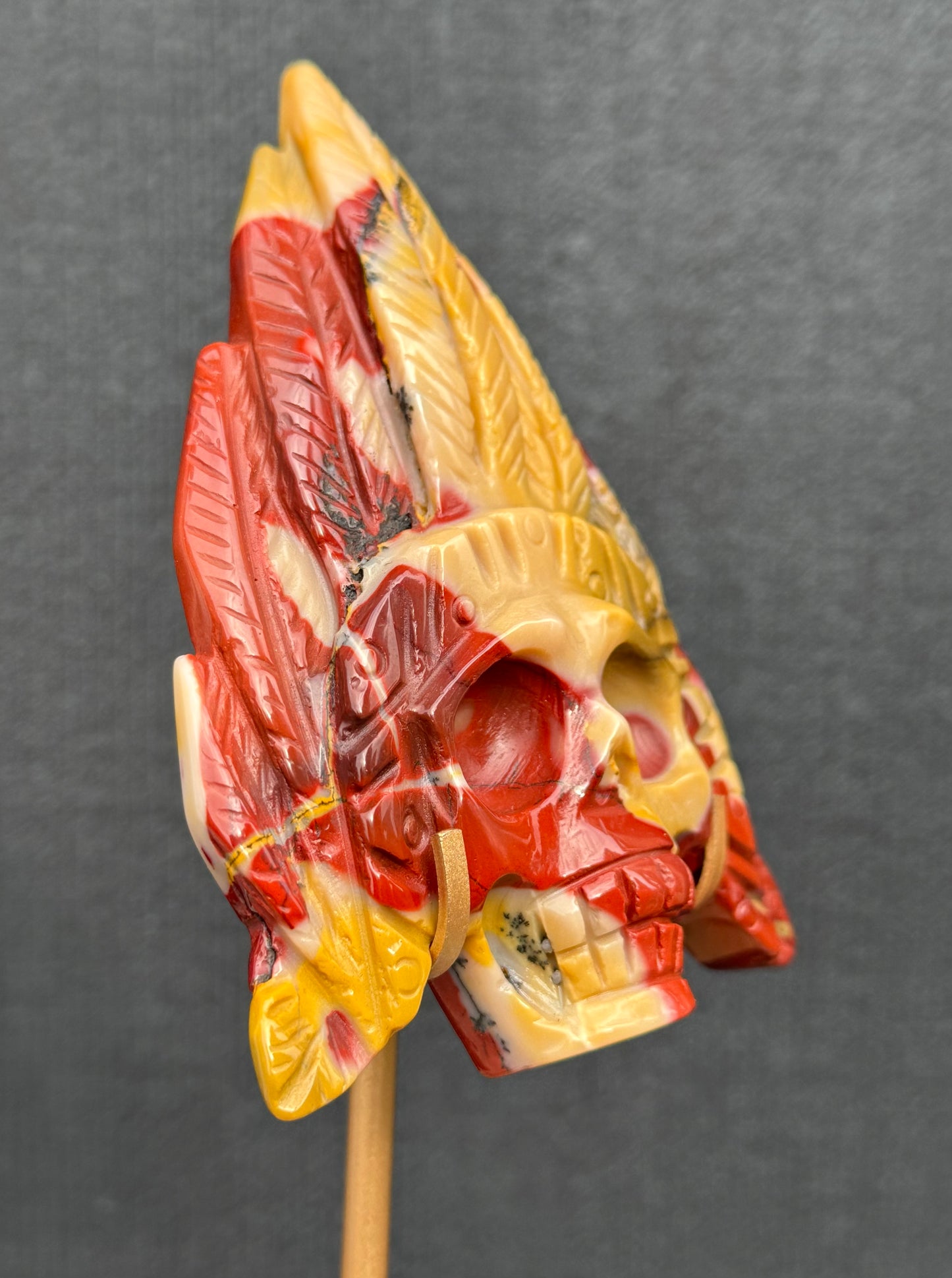 Mookaite Jasper carved Skull with Feathers on a stand
