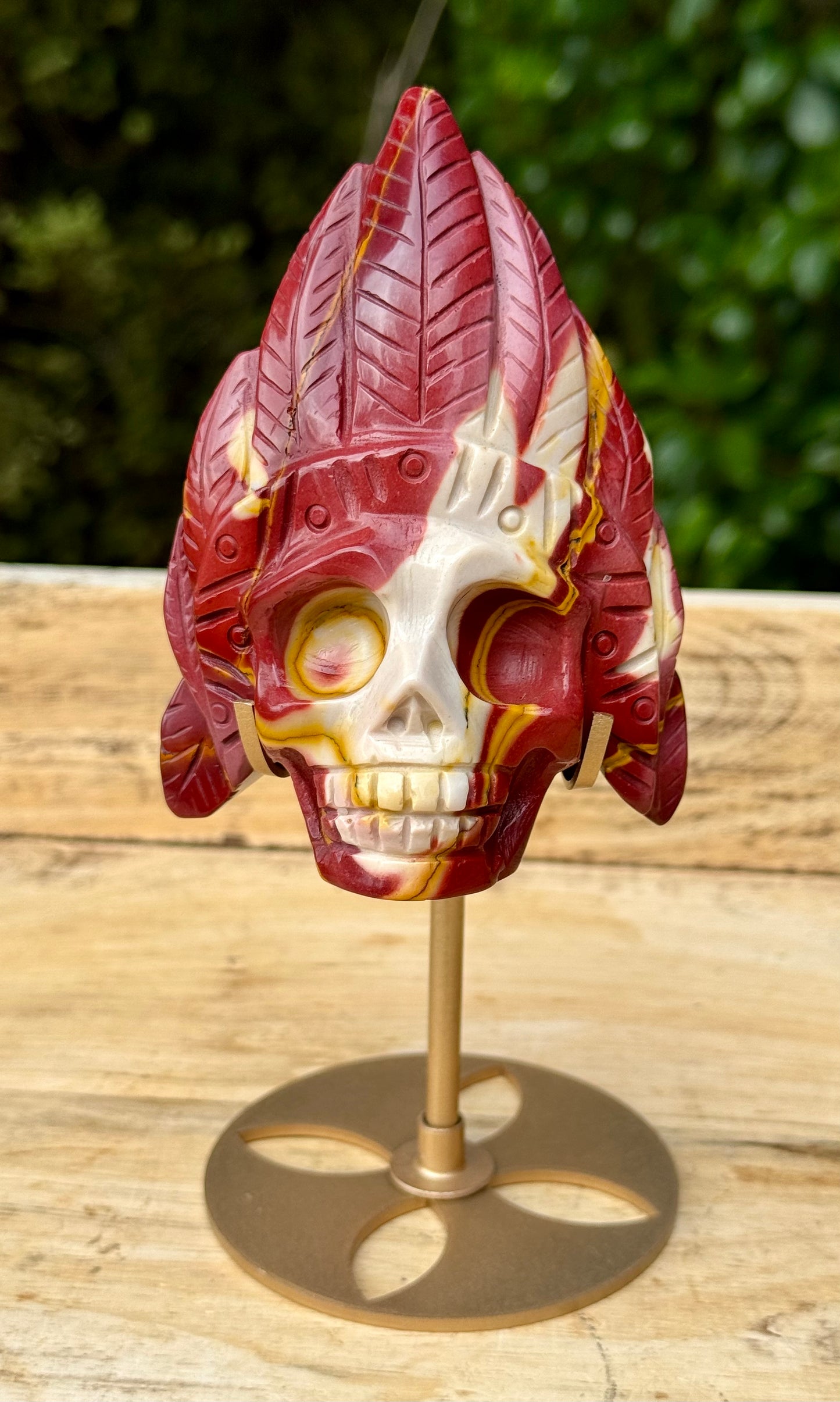 Mookaite Jasper carved Skull with Feathers on a stand
