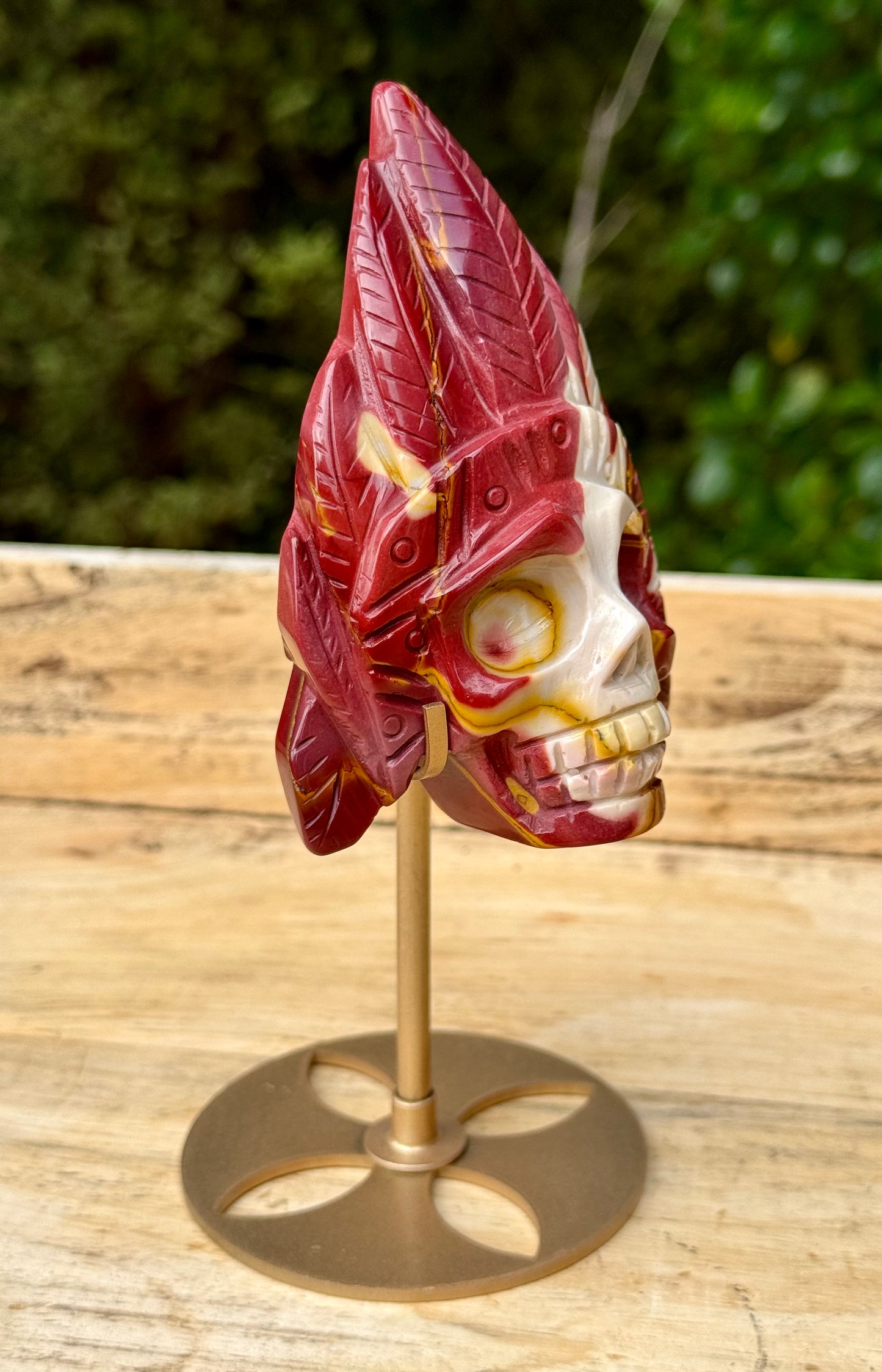Mookaite Jasper carved Skull with Feathers on a stand