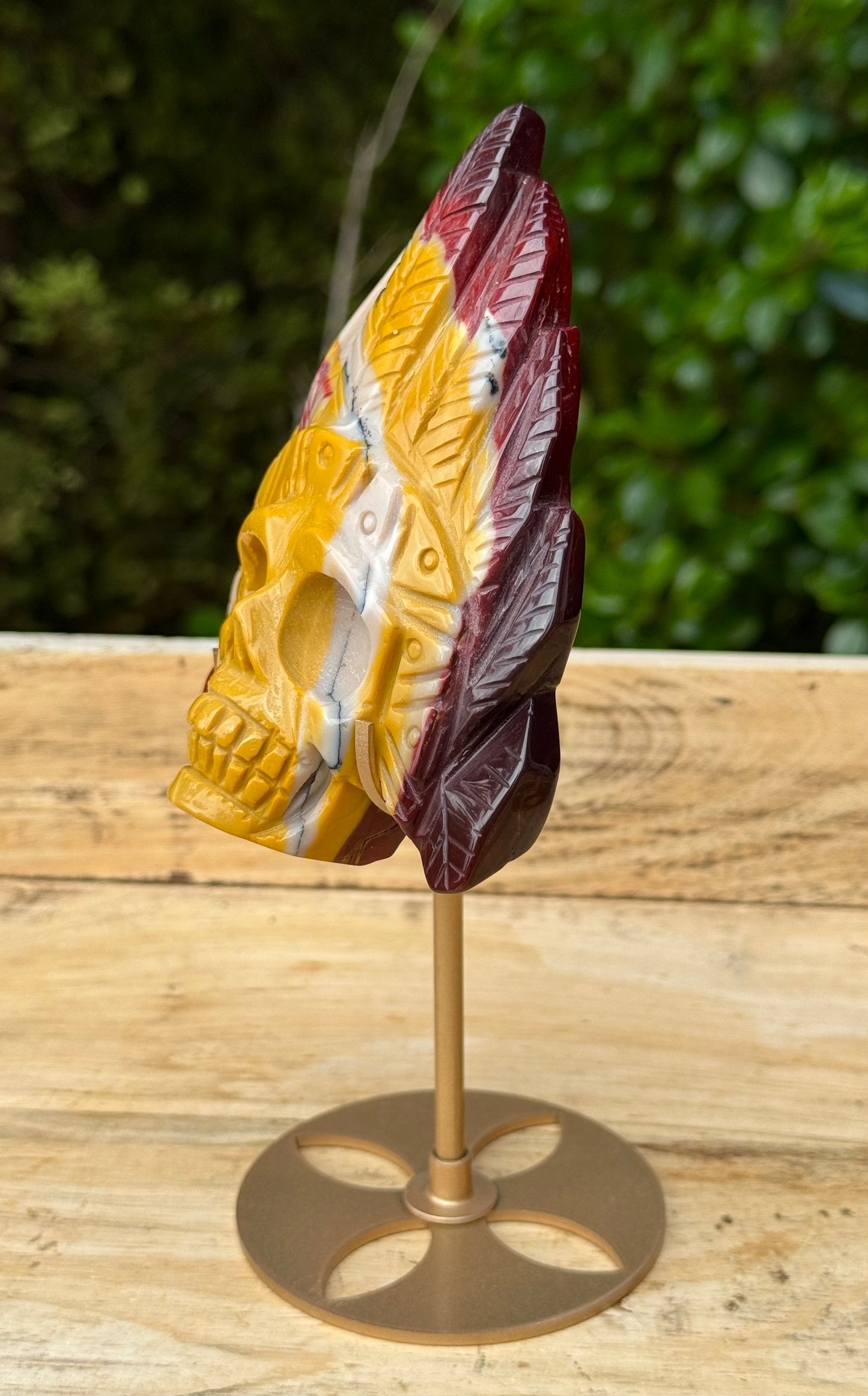 Mookaite Jasper carved Skull with Feathers on a stand