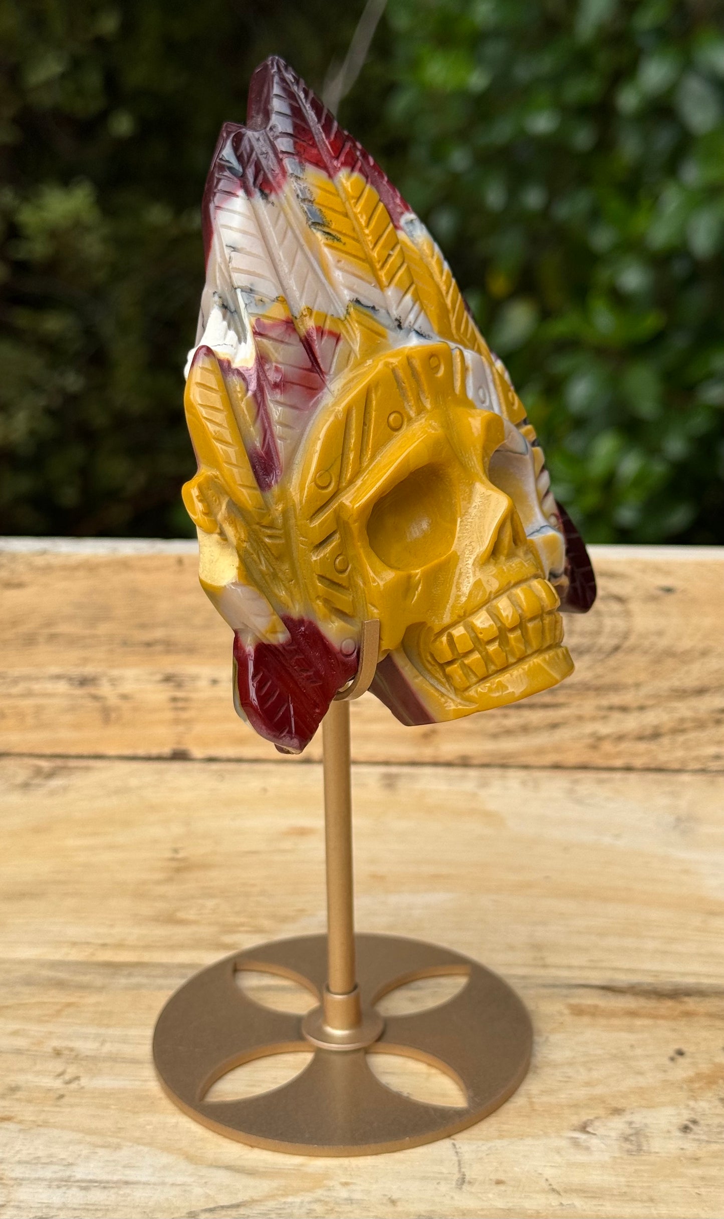 Mookaite Jasper carved Skull with Feathers on a stand