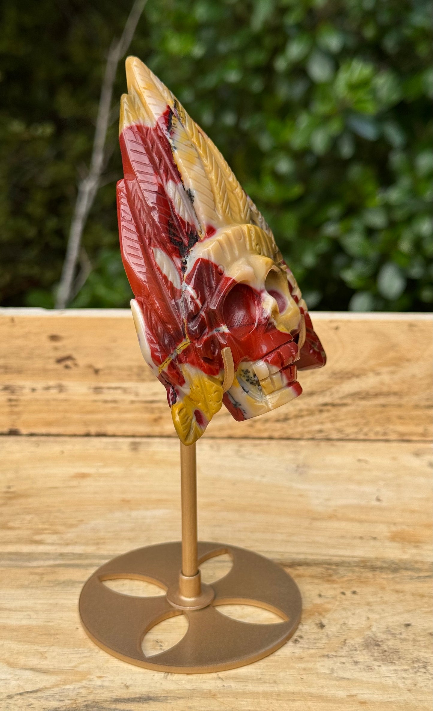 Mookaite Jasper carved Skull with Feathers on a stand