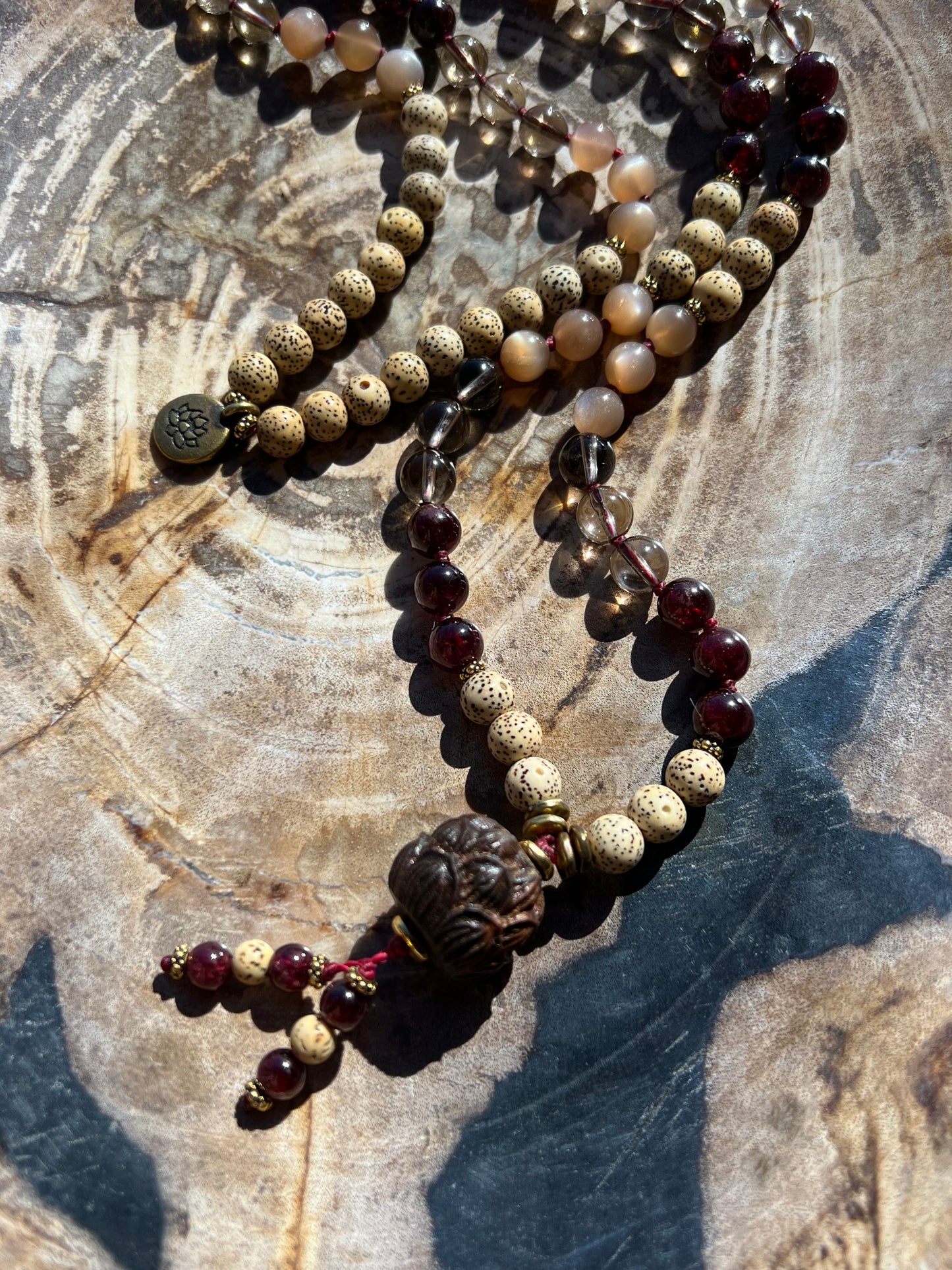 Mālā with Garnet, Smoky Quartz, Sunstone and Lotus Seed Beads with a Carved Lotus Guru Bead/ Pendant