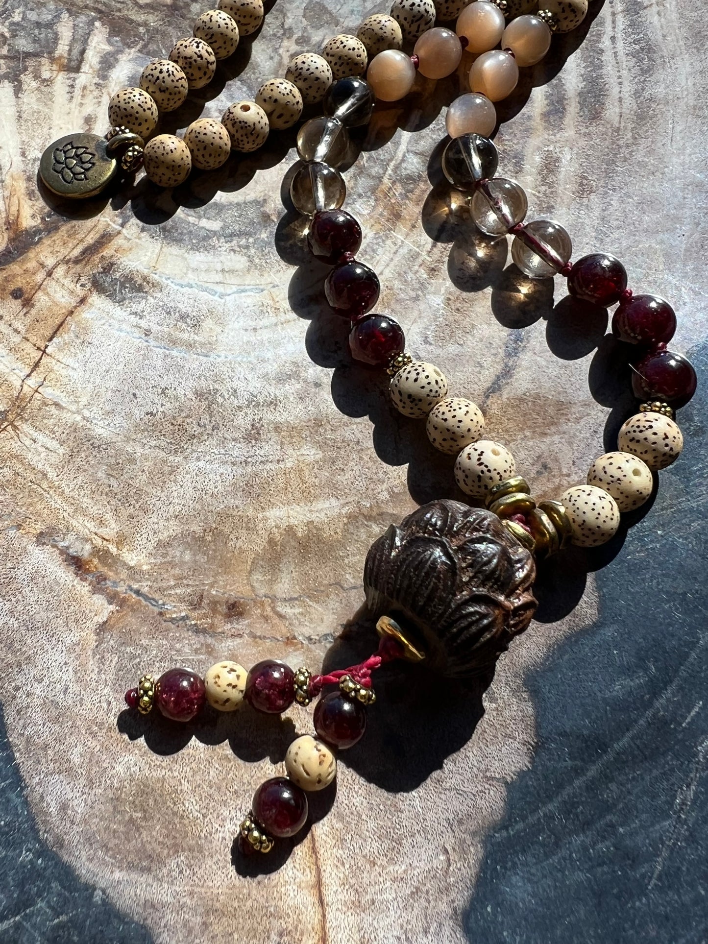 Mālā with Garnet, Smoky Quartz, Sunstone and Lotus Seed Beads with a Carved Lotus Guru Bead/ Pendant