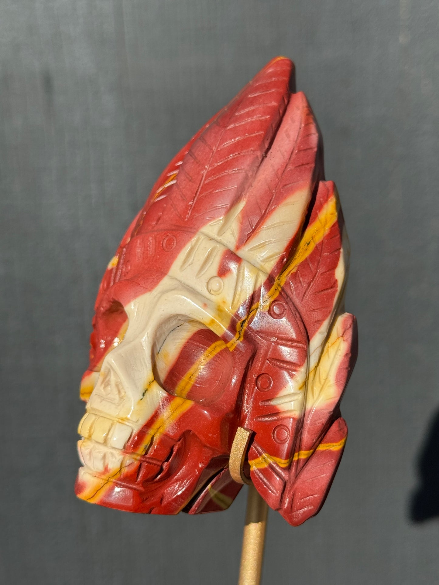 Mookaite Jasper carved Skull with Feathers on a stand