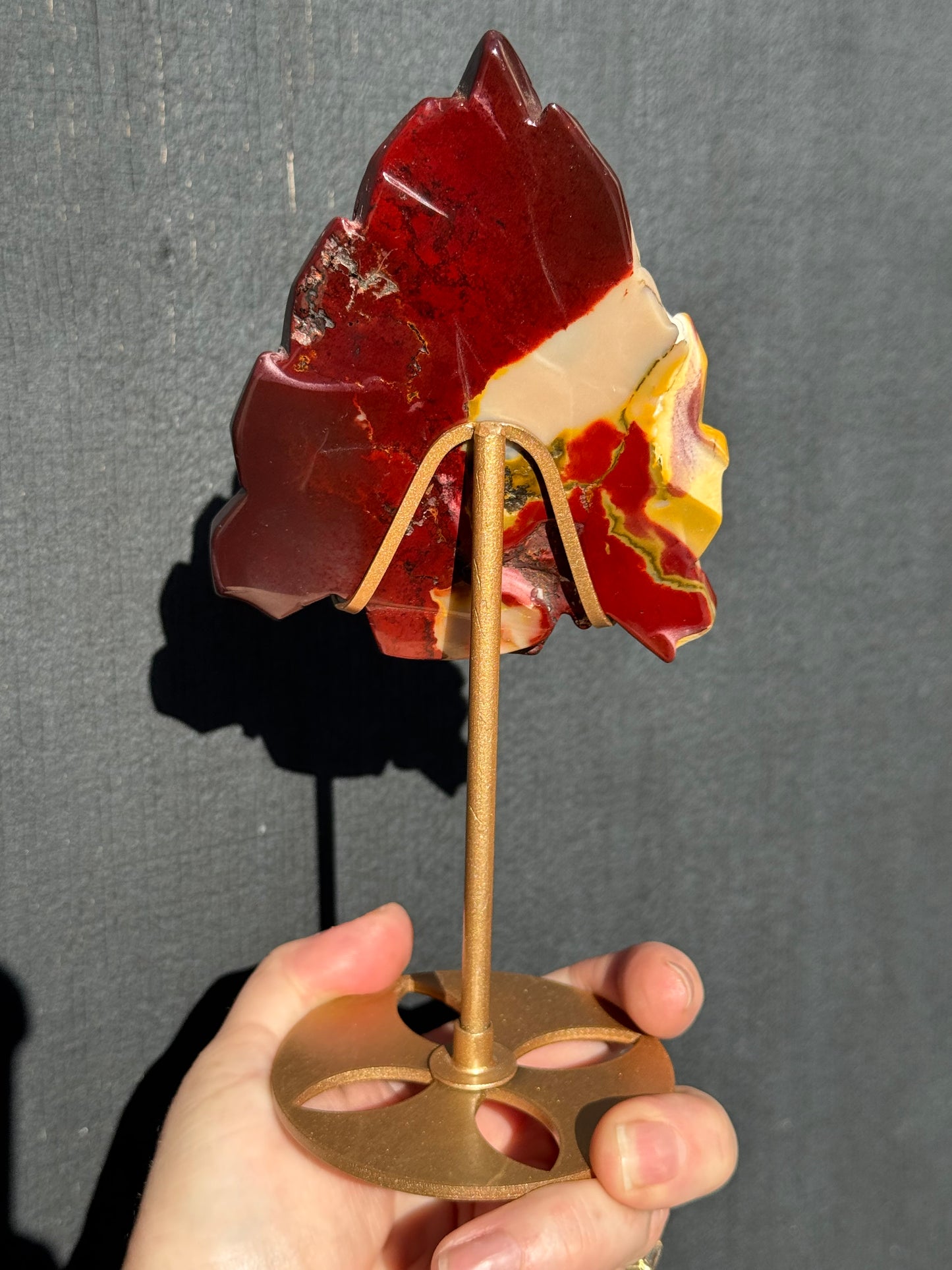 Mookaite Jasper carved Skull with Feathers on a stand